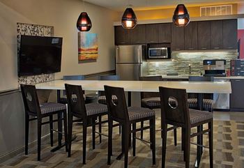 A kitchen with a table and chairs.